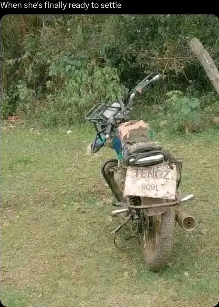 Motorcycle Parked In The Grass With a motorcycle parked in the grass with a sign on it